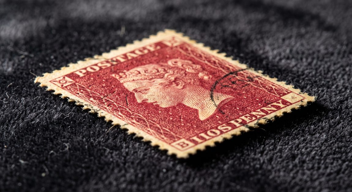 Macro close-up of a rare classic red postage stamp on dark velvet