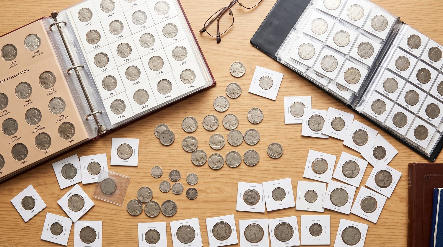 a diverse inherited coin collection on a wooden desk, featuring Buffalo Nickels, Liberty Head Nickels, and Half Dimes scattered among open coin albums, flips