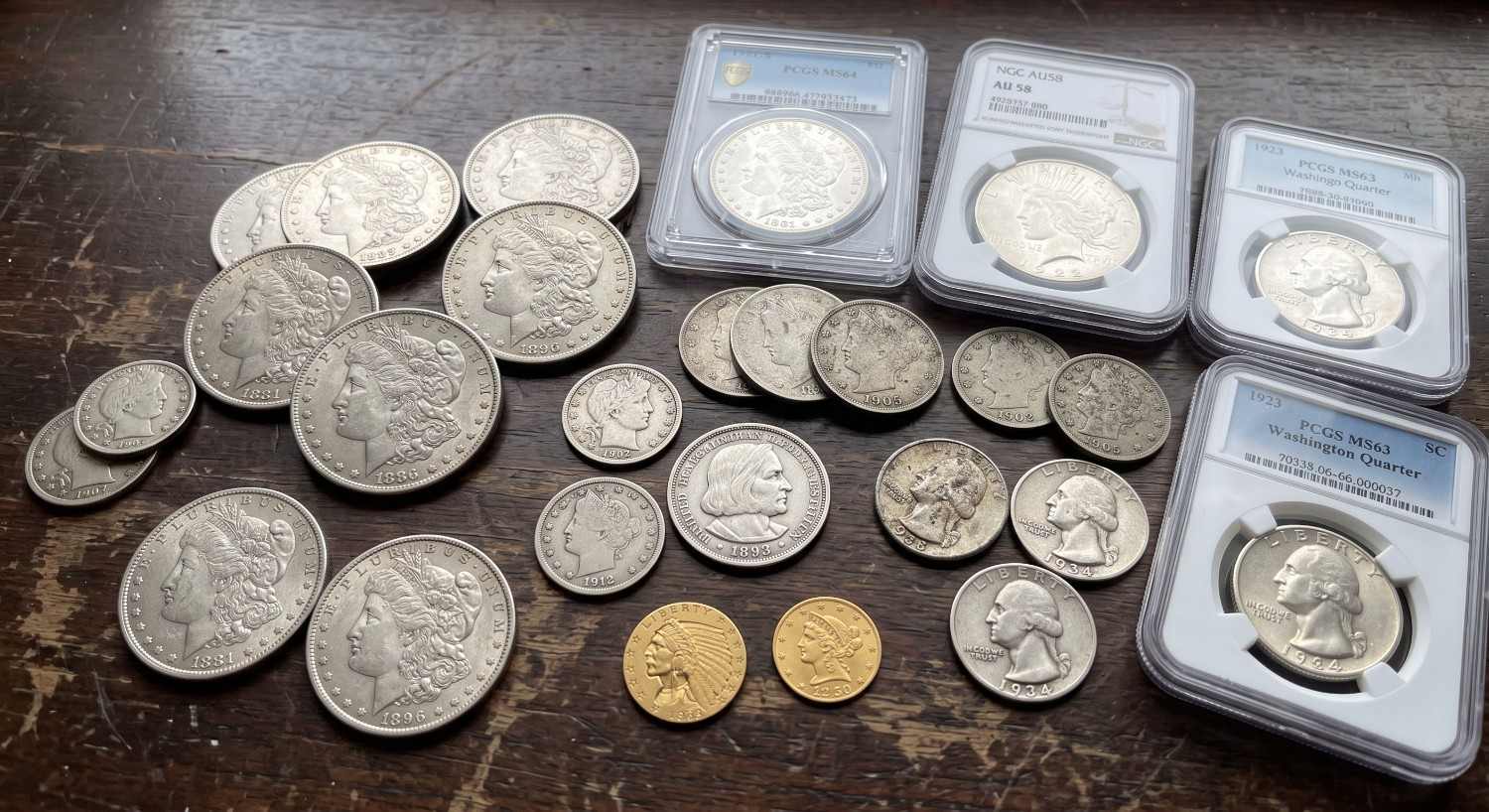 A pile of Morgan and Peace silver dollars
